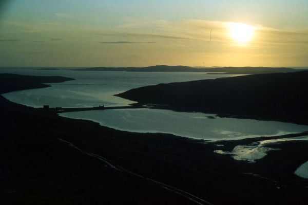 Most of the land is still in shadow as the sun rises.